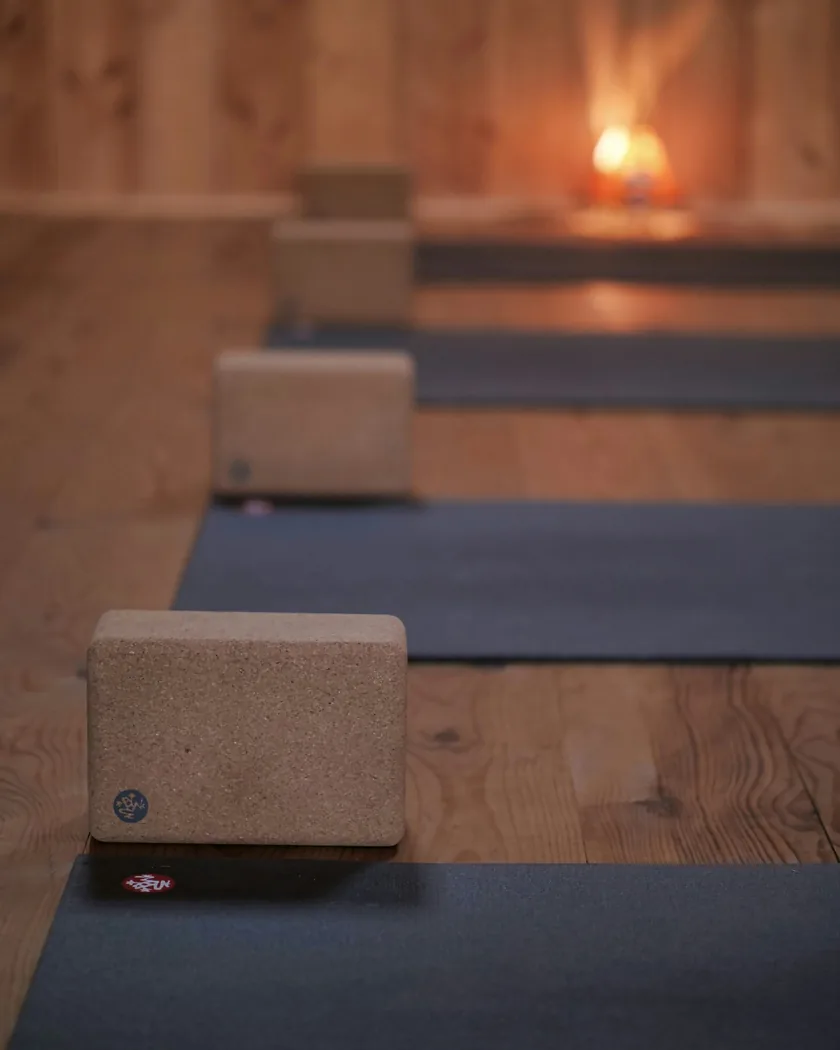 Tapis de yoga alignés sur un plancher en bois clair, vus de haut