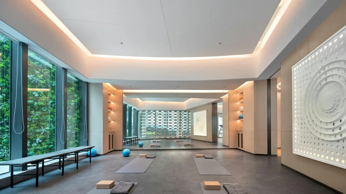 Salle de pratique aux grandes fenêtres, tapis alignés sur un parquet clair